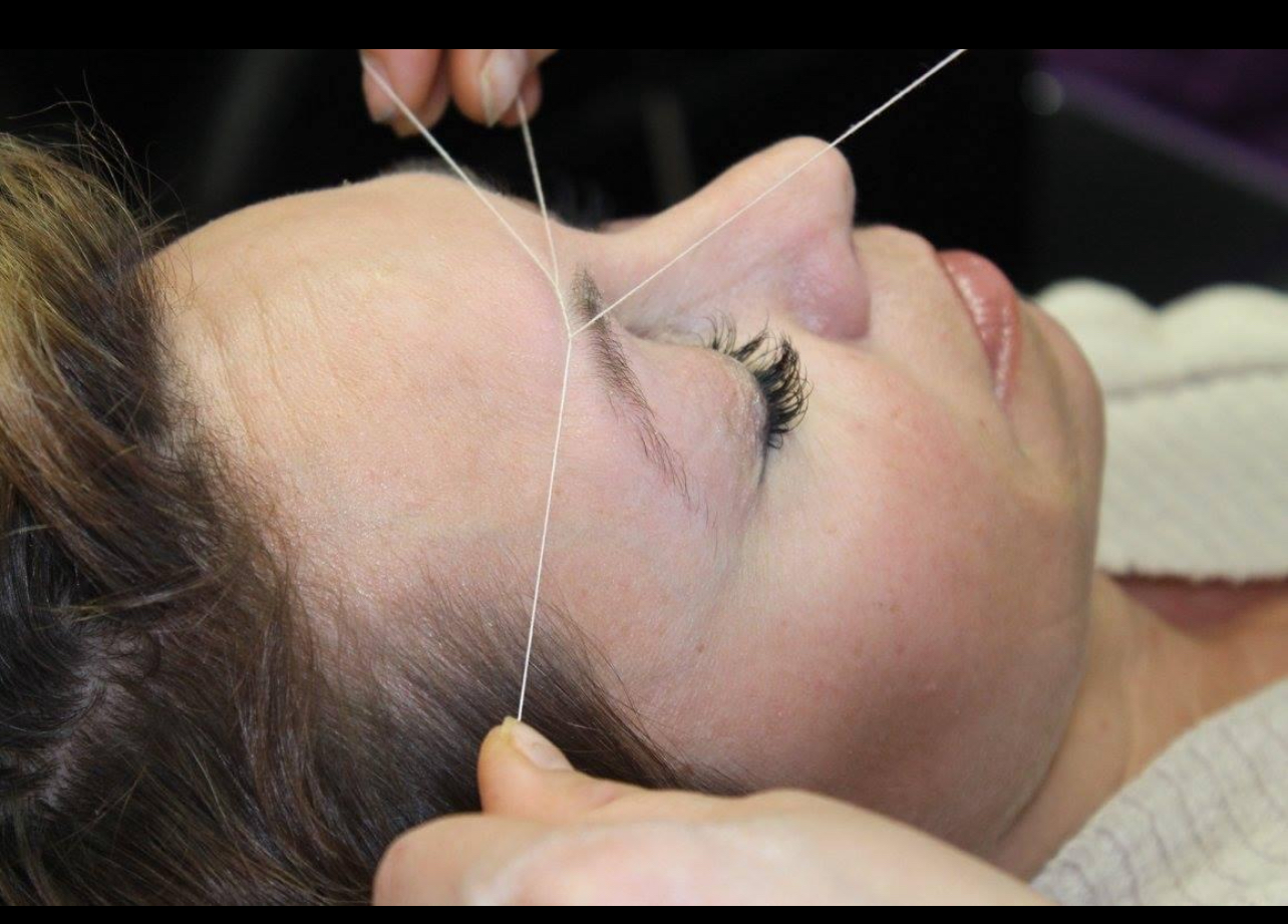 Facial threading in progress